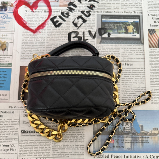 black small vanity handbag with metal chain strap